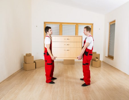 Commercial moving team handling desks and boxes in a Balham premises